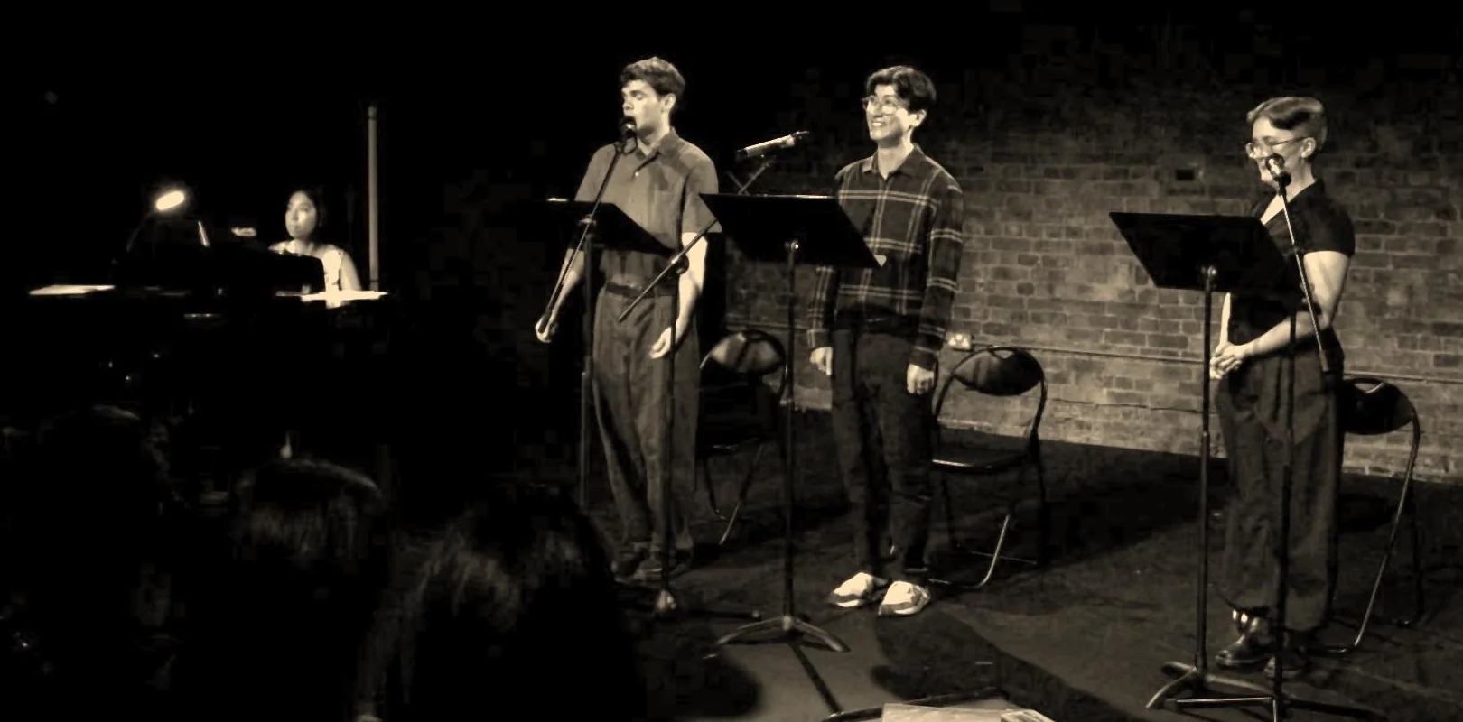 Charlie Renwick as Siegfried Sassoon, Josh Liew as Wilfred Owen and Maddie Gray as the Witness at microphones, with Tamiko Dooley at the piano on the left, at The Union Theatre.