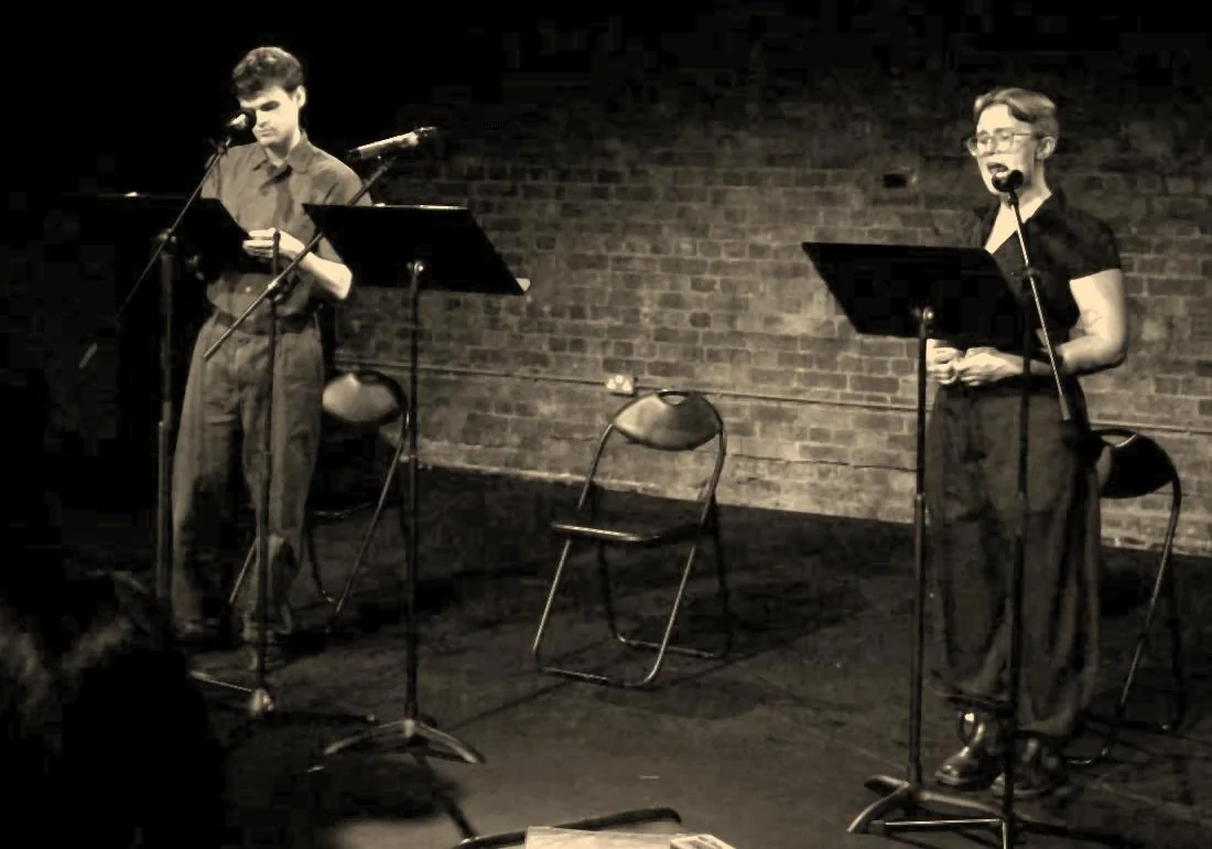 Charlie Renwick as Siegfried Sassoon and Maddie Gray as the Witness performing at microphones at The Union Theatre.